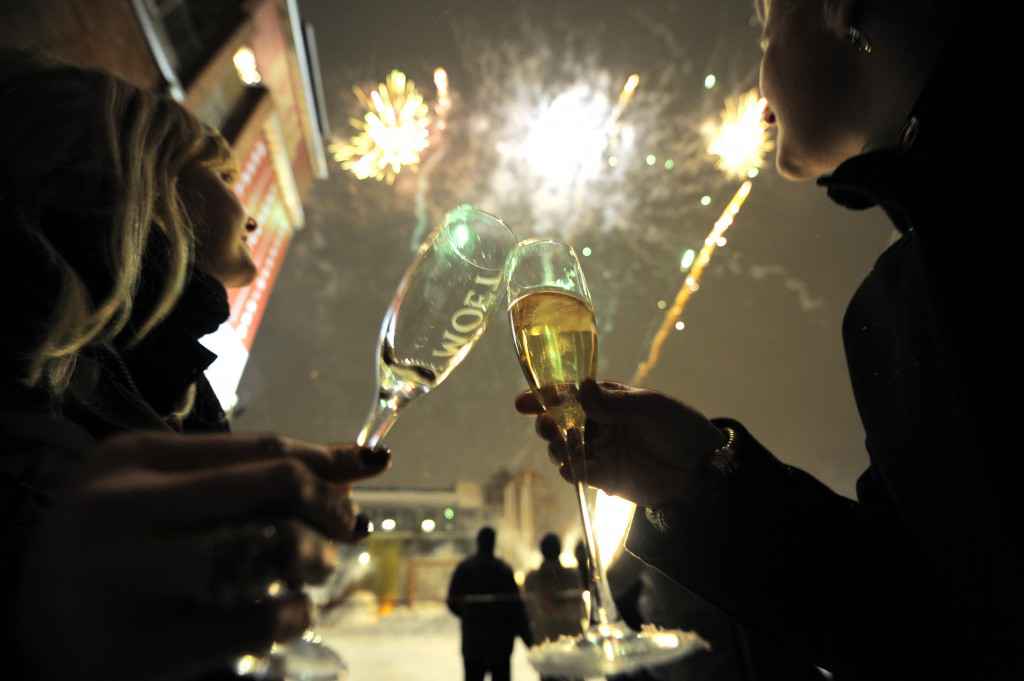 Two women toast as fireworks explode dur